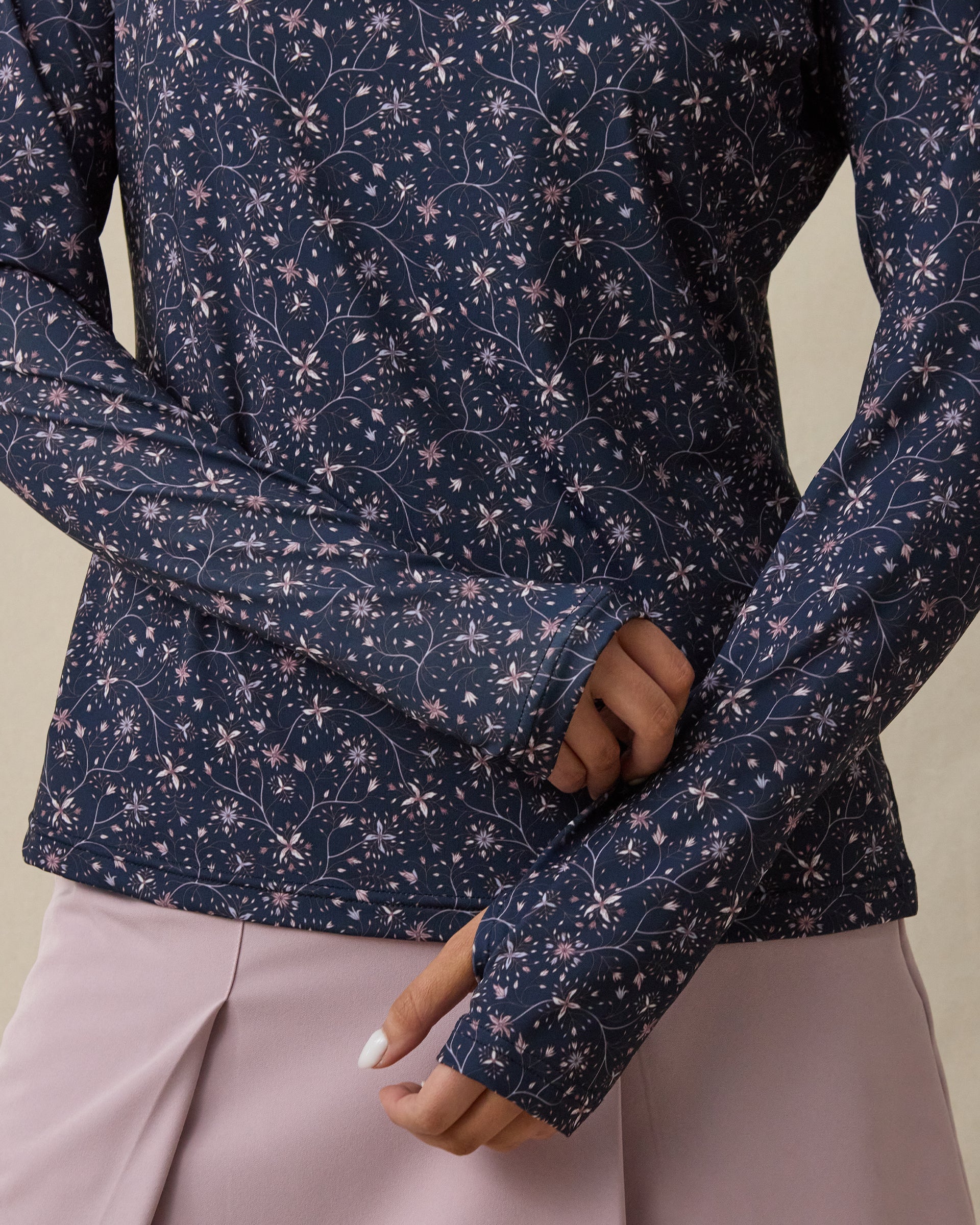Close-up of the Erika Quarter Zip in New Indigo showing the floral vine print and thumbhole cuff detail