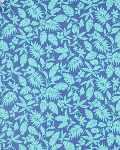 A close-up of a tropical leaf and floral pattern in light aqua green on a medium periwinkle blue background.