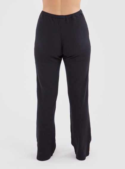 Misty Pant in Black, back on-model view featuring solid black wide-leg pants with a waffle knit texture and elastic waistband
