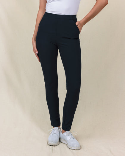 Lexi Pant in Black, front view on model featuring solid black fabric with side pockets and clean waistband styled with a white top and white shoes