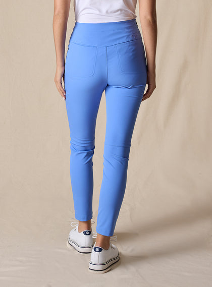 Lexi Pant in Maison, back view on model featuring solid medium blue fabric with wide waistband, back pockets, and tonal Straight Down logo embroidery styled with a white top and white shoes