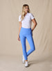 Lexi Pant in Maison, full length front view on model featuring solid medium blue fabric styled with a white short sleeve polo and white shoes
