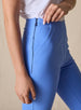 Lexi Pant in Maison, close up detail view on model showing the side zip closure, wide waistband, tonal logo embroidery, and center front seam detail in solid medium blue fabric