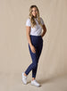 Lexi Pant in New Indigo, full length front view on model featuring solid navy fabric styled with a white short sleeve polo and white shoes