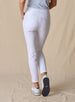 Lexi Pant in White, back view on model featuring solid white fabric with back pockets and clean waistband styled with a light blue polo and white shoes