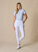 Lexi Pant in White, full length front view on model featuring solid white fabric styled with a light blue short sleeve polo and white shoes