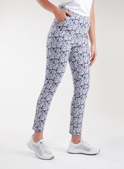 Lexi Pant in White Indigo, side view on model featuring a navy and white all-over daisy floral print with hand in side pocket styled with white shoes