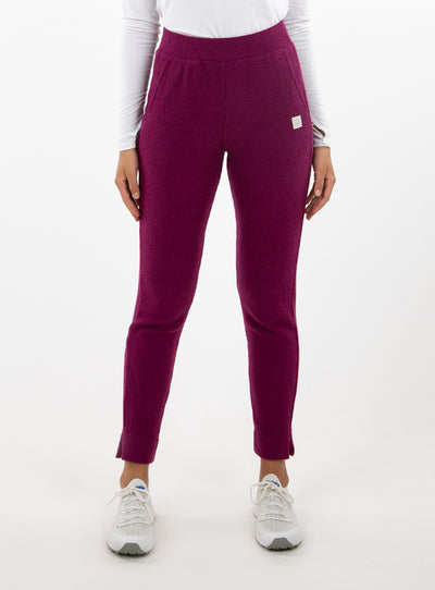 Women's Mavis Jogger in Dark Raspberry, front model view featuring a deep berry waffle-knit jogger with elasticated waistband, side pocket with Straight Down logo patch, and ankle vent detail paired with a white long sleeve top and white athletic shoes