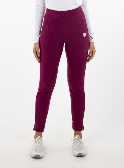 Women's Mavis Jogger in Dark Raspberry, front model view featuring a deep berry waffle-knit jogger with elasticated waistband, side pocket with Straight Down logo patch, and ankle vent detail paired with a white long sleeve top and white athletic shoes