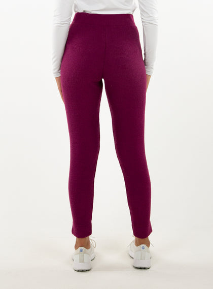 Women's Mavis Jogger in Dark Raspberry, back model view featuring a deep berry waffle-knit jogger with elasticated waistband, clean back panel, and tapered leg with cuffed hem paired with a white long sleeve top and white athletic shoes