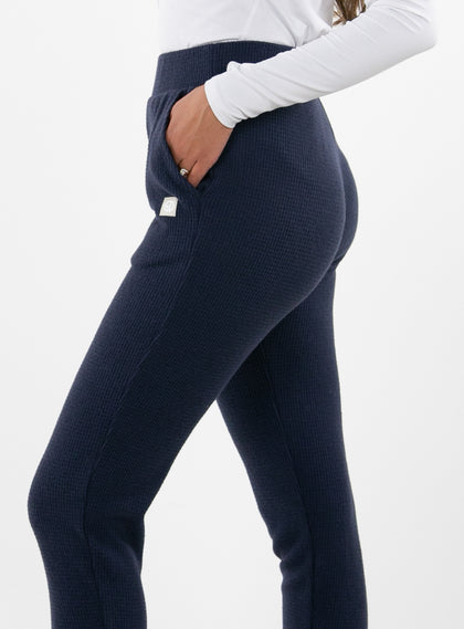 Women's Mavis Jogger in Ink, close-up side model view featuring a navy waffle-knit jogger with elasticated waistband, side pocket with tonal Straight Down logo patch, and front seam detail