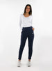 Women's Mavis Jogger in Ink, full length model view featuring a navy waffle-knit jogger with elasticated waistband, Straight Down logo patch, and tapered leg with ankle vent detail paired with a white long sleeve top and white athletic shoes