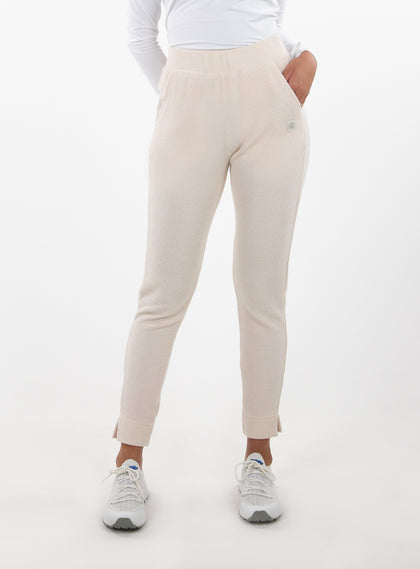 Women's Mavis Jogger in Oyster, front model view featuring an off-white waffle-knit jogger with elasticated waistband, side pocket with tonal Straight Down logo, and ankle vent detail paired with a white long sleeve top and white athletic shoes