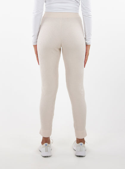 Women's Mavis Jogger in Oyster, back model view featuring an off-white waffle-knit jogger with elasticated waistband, clean back panel, and tapered leg with cuffed hem paired with a white long sleeve top and white athletic shoes