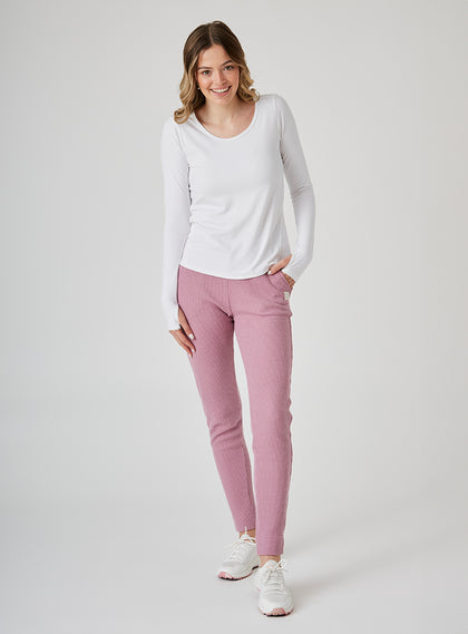 Women's Mavis Jogger in Peonie, full length model view featuring a dusty rose waffle-knit jogger with elasticated waistband, tonal Straight Down logo patch, and tapered leg with ankle vent detail paired with a white long sleeve top and white athletic shoes