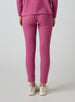 Women's Mavis Jogger in Rosewine, back model view featuring a bold rose waffle-knit jogger with elasticated waistband, clean back panel, and cuffed hem paired with a matching waffle-knit top and white athletic shoes
