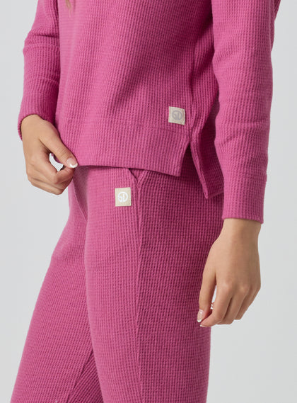 Women's Mavis Jogger in Rosewine, close-up model view featuring a bold rose waffle-knit jogger with elasticated waistband, angled side pocket, and tonal Straight Down logo patch alongside a matching waffle-knit top with Straight Down logo patch