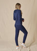 Women's Topia Jogger in New Indigo, full length back model view featuring a navy smooth-knit jogger paired with a matching Mesa Hooded Jacket and white athletic shoes
