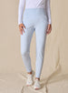 Women's Topia Jogger in Powder, front model view featuring a soft blue smooth-knit jogger with wide elasticated waistband and cuffed hem paired with a white long sleeve top and white athletic shoes