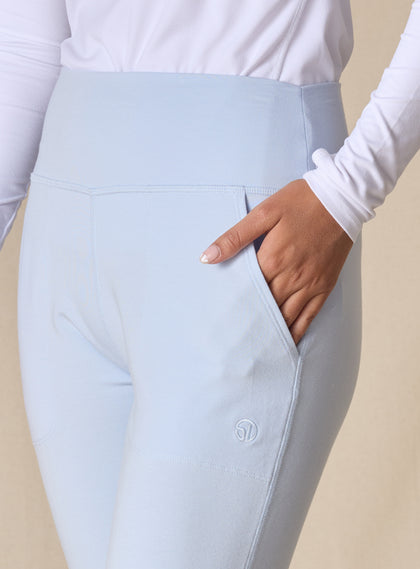 Women's Topia Jogger in Powder, close-up model view featuring a soft blue smooth-knit jogger with wide elasticated waistband, angled side pocket, and tonal Straight Down logo embroidery
