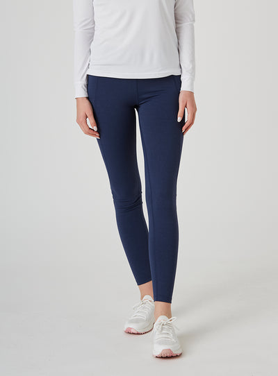 Sedona Legging in New Indigo, on model front view showing the solid navy high-waisted legging with side pockets, styled with a white long sleeve top