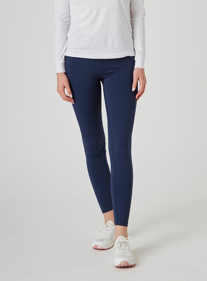 Sedona Legging in New Indigo, on model front view showing the solid navy high-waisted legging with side pockets, styled with a white long sleeve top