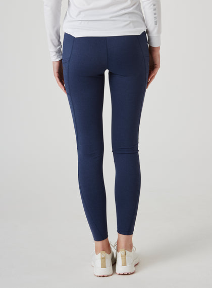Sedona Legging in New Indigo, on model back view showing the solid navy high-waisted legging with side pockets, styled with a white long sleeve top