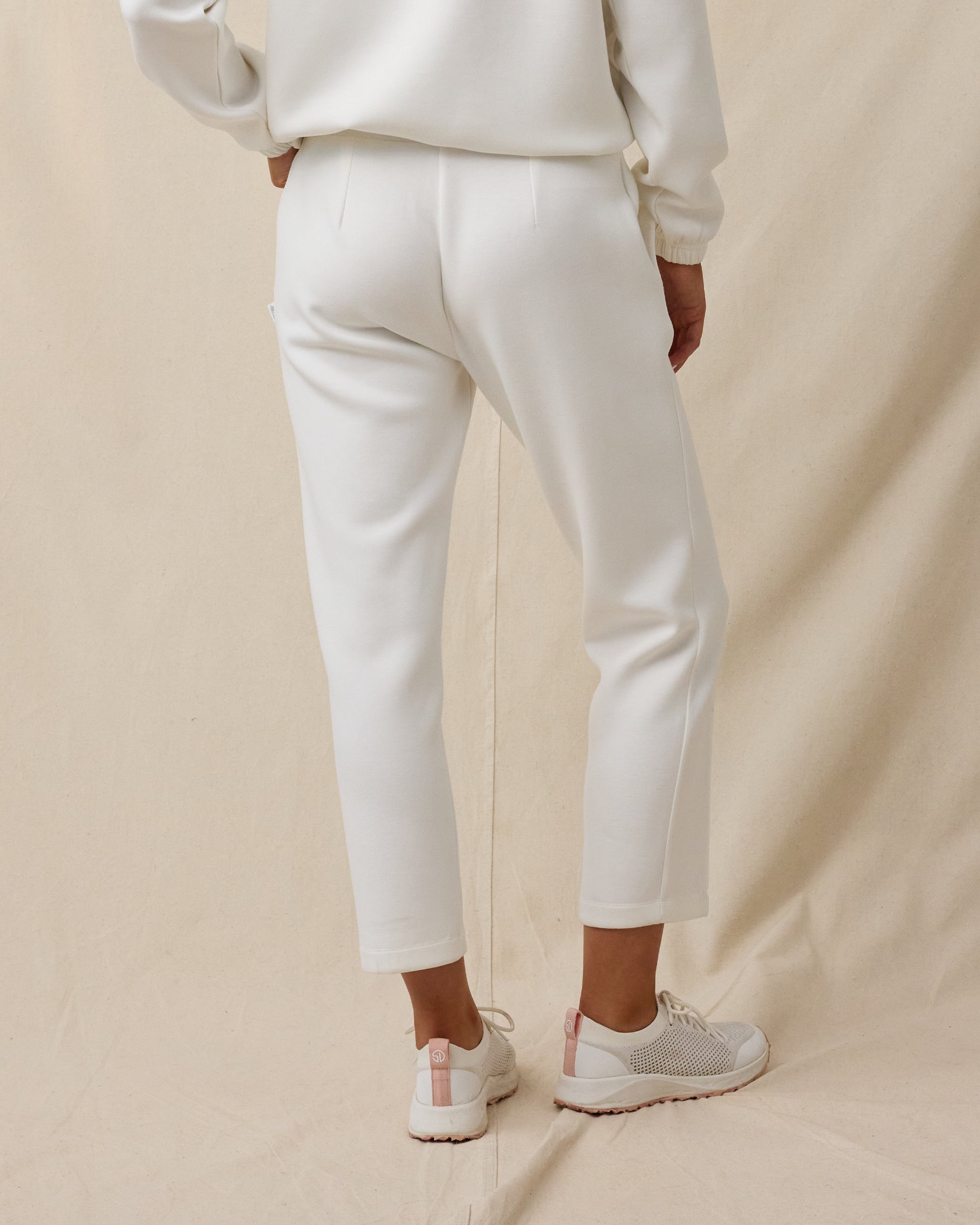 Woman wearing the Chelsea Pant in Coconut, showing the high-rise fit, front pleats, and cropped length.