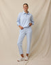 Woman wearing the Chelsea Pant in Lake with a matching long-sleeve polo and white sneakers.