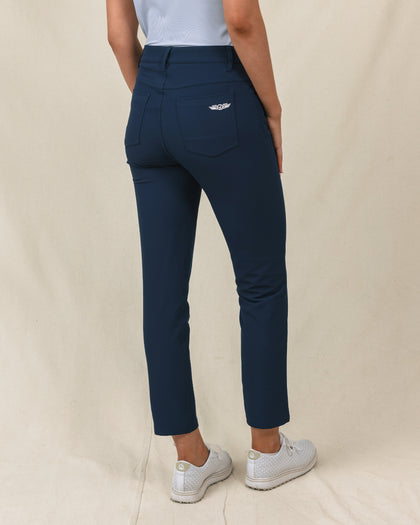 Stride Pant in New Indigo, back view on model in solid navy with Straight Down logo embroidered on back pocket, paired with white golf shoes