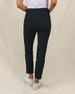 Women's Stride Pant in Black, back view on model featuring black ankle-length pants with two back pockets and Straight Down logo embroidery, paired with a white top and white golf shoes
