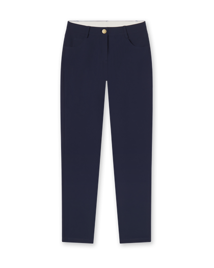 Women's Stride Pant in New Indigo, flat lay front view featuring solid navy fabric, front hip pockets, gold logo button closure, and a tapered leg