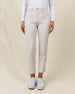 Women's Stride Pant in Stone, front view on model featuring a stone colored ankle pant with front patch pockets and gold button closure, paired with a white long sleeve polo and white golf shoes