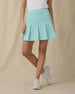 Women's Martina Skort in Green Stone, front on-model view from the waist down featuring a solid mint green pleated skort with a wide waistband, paired with a white top and white shoes