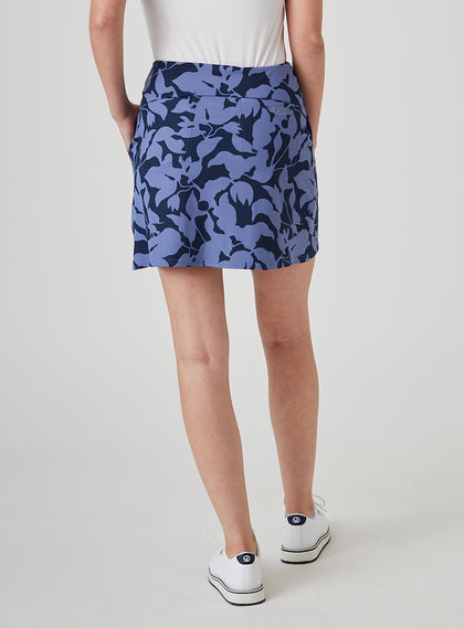 Women's Evie Skort in Blueberry, back model view featuring a navy and steel blue bold abstract floral print skort with a Straight Down logo embroidered at the back waistband and white shoes