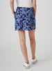 Women's Evie Skort in Blueberry, back model view featuring a navy and steel blue bold abstract floral print skort with a Straight Down logo embroidered at the back waistband and white shoes