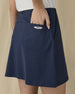 Evie Skort in New Indigo, close-up back view on model highlighting the back patch pocket and Straight Down logo detail