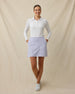 Model wearing the Evie Skort in Cosmic Blue paired with a white long-sleeve polo