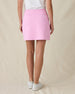 Evie Skort in Pink Floyd, back view on model in solid pink with back pockets and Straight Down logo embroidered in white, paired with white golf shoes