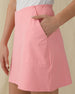 Women's Evie Skort in Geranium, close-up detail view featuring the side pocket and clean seam detailing on a pink skort