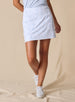 Women's Ava Skort in Powder, front view featuring an allover scattered floral print with light blue blooms on a white base, paired with a light blue top and white golf shoes