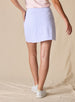 Women's Kyoto Skort in Hydrangea, on model back view showing the all-over blue geometric hexagon and floral print and Straight Down logo at the waistband with white golf shoes