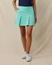 Korra Skort in Cascade Green paired with a navy polo, front model view