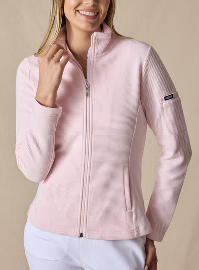 Swing Jacket in Light Pink, front view on model featuring solid light pink fabric with subtle horizontal texture, full zip closure, and stand collar styled with white pants