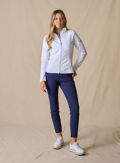 Swing Jacket in White, full length front view on model featuring solid white fabric with subtle horizontal texture and full zip closure styled with navy pants and white shoes