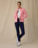 Women's Swing Jacket in Geranium, full length front view on model featuring a pink full zip jacket with a ribbed texture worn open over a white polo, paired with navy pants and white golf shoes