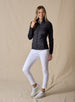 Nova Jacket in Black, side view on model featuring a black hybrid full-zip jacket with diagonal quilted front, stretch knit sleeves, and mock neck collar styled with white pants and white shoes