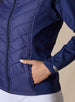 Nova Jacket in Indigo, close-up front view on model featuring the diagonal quilted body, side zip pocket with hand inserted, and silver embroidered logo detail on the cuff