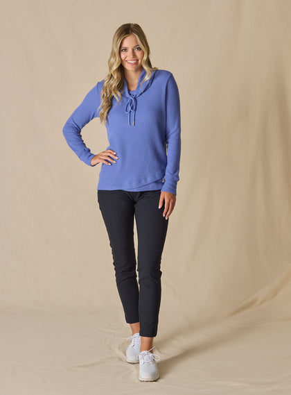Women's Misty Top in Blueberry, full length front view on model featuring a solid blueberry waffle knit long sleeve top with cowl neck and drawstring tie, paired with black pants and white shoes