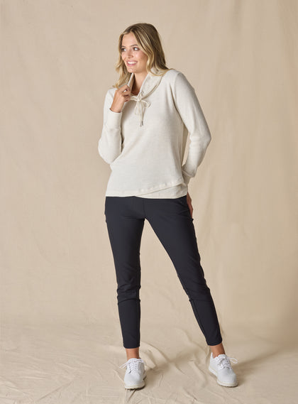  Women's Misty Top in Oatmeal, full length front view on model featuring a cream waffle knit long sleeve top with cowl neck and drawstring tie, paired with black pants and white sneakers